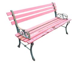A Victorian style garden bench, the slatted back and seat with cast iron ends and pierced scroll