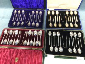 Four hallmarked silver cased sets of teaspoons, each set of twelve complete with tongs -