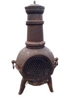 A cast iron chimera stove, the tapering chimney with cover above a burning chamber with arched