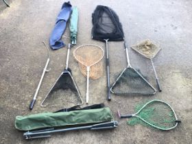 Six miscellaneous fishing landing nets - telescopic, folding, large, etc; a sleeved fishing umbrella