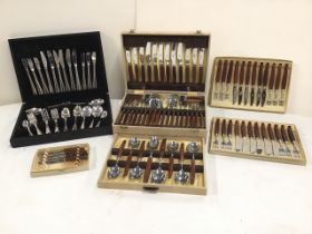 A 60s cased cutlery canteen with six settings having wood handles, three matching boxed sets of