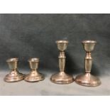 A pair of hallmarked silver candlesticks with urn shaped candleholder on columns - Birmingham