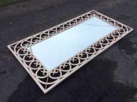 A rectangular painted metal full length mirror, with riveted and welded open scrolling strap work