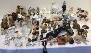 A large collection of ceramic, glass and resin animal figurines, including groups of boxer dogs,