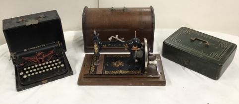 A cased Edwardian hand-cranked sewing machine, with ceramic handle and gilt rose transfers; a