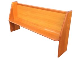 A modern hardwood pew, the chamfered toprail above a rectangular back and a seat with canted