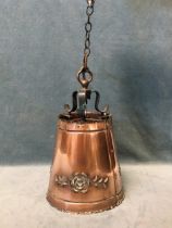 An arts and crafts copper hanging light, the conical shade with embossed pierced floral decoration