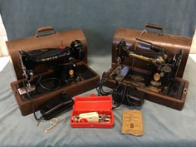 Two Edwardian walnut cased cast iron Singer sewing machines, both with various accessories, the