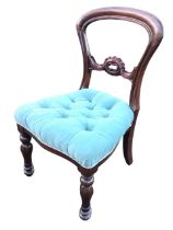 A Victorian mahogany balloon back chair, with carved pierced rail above a button upholstered