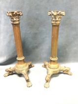 A pair of Victorian brass roman style candlesticks, the fluted corinthian columns on turned bases,