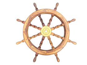 A mahogany ships wheel, the brass hub with eight double baluster spokes with turned handles. (33in)