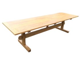 A contemporary 9ft oak refectory table, the rectangular top with cleated ends, raised on square