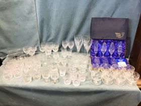 A large quantity of cut glass drinking glasses and dessert bowls including two Tutbury Crystal boxed