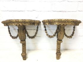 A pair of nineteenth century giltwood corbel brackets with scalloped D shaped shelves having