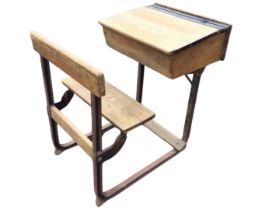 An oak school desk, the top with pen tray and inkwell above a sloping writing surface, the hinged