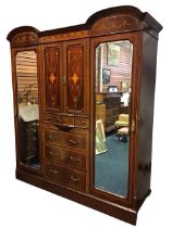 An Edwardian satinwood banded and inlaid combination wardrobe, the double arched cornice above an