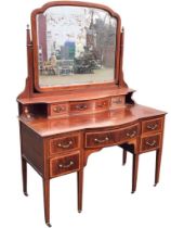 An Edwardian satinwood crossbanded mahogany bowfronted dressing table, the arched bevelled mirror