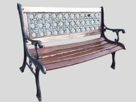 A cast iron and painted hardwood garden bench, the rectangular back with pierced panel simulating