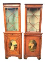 A near pair of Edwardian Sheraton Revival painted satinwood corner cabinets, the moulded cornices