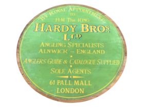 A circular pine advertising panel for Hardy Bros of Alnwick, the battened board applied with a
