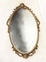 An oval gilt metal framed mirror with ropetwist frame having applied acanthus scrolled leaf