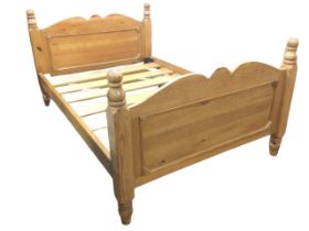 A pine double bed, the panelled head and foot board with bow crestrails, flanked by square corner