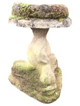 A composition stone garden birdbath with triangular dolphin support to an associated moulded bowl on