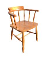 An elm and beech captains chair with horseshoe shaped spindle back and arms, above a solid dished