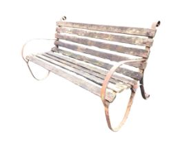 A 5ft wrought iron garden bench with slatted back and seat on scrolled strapwork supports. (60in)