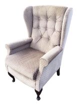 A Georgian style upholstered wing armchair, the buttoned back above a rectangular seat with loose