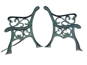 A pair of cast iron bench ends with scrolled arms and frames raised on channelled flared sabre legs.