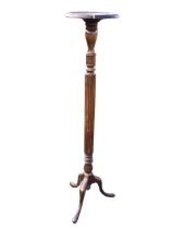 An Edwardian mahogany torchere stand, the circular top with reel and bead moulding, on a turned