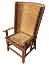 A 50s oak orkney armchair, the woven straw barrel back above a seagrass seat, flanked by shaped