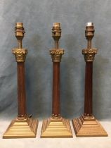 A set of three contemporary fluted corinthian column tablelamps with scrolled capitals and square