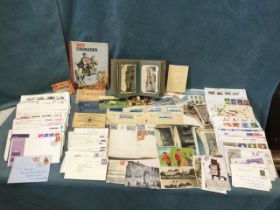 An album of European postcards; two ‘schoolboy’ stamp albums; a quantity of first day covers; and