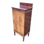 An Edwardian chequer strung mahogany music cabinet, the raised back with moulded cornice above an