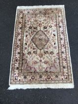 A Kashan wool and silk rug, the ivory field with floral medallion amidst scrolling flowers and