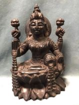 An Indian carved hardwood figure of the goddess Lakshmi, seated on a lotus flower. (10.25in)