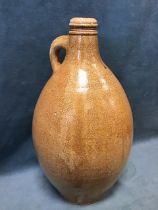 A C18th German saltglazed stoneware bellarmine jug, the moulded rim above an ovoid body with pale