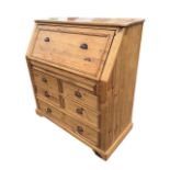 A Victorian style pine bureau, the sloped panelled front fitted opening on lopers to a writing