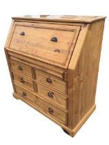 A Victorian style pine bureau, the sloped panelled front fitted opening on lopers to a writing