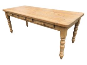 A Victorian style pine kitchen table, the rectangular top above three frieze drawers, raised on