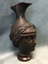 A C19th Italian Grand Tour Etruscan style bronze ewer cast in the form of a female head wearing a