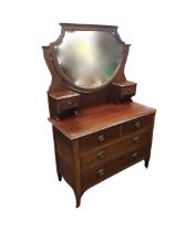 An Edwardian mahogany dressing chest, the shield shaped bevelled mirror with boxwood strung frame on