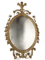 An antique gilt mirror with later oval plate in leaf-scale carved frame having applied gesso