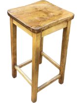 An elm and beech stool, the figured dished rectangular seat raised on square legs joined by pegged