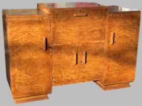 An art deco walnut cocktail cabinet, the stepped top having opening central section with fitted