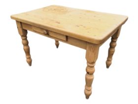 A Victorian style pine kitchen table, the rectangular top above a frieze knobbed drawe, raised on