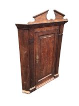 A C19th oak hanging corner cupboard, the broken pediment and moulded cornice above a rectangular