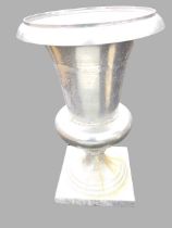 A large contemporary aluminium garden urn with flared tapering body and moulded rim on sockle,